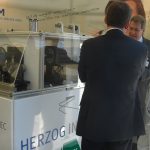 Interested parties in front of the HERZOG INTERTEC trade fair test stand